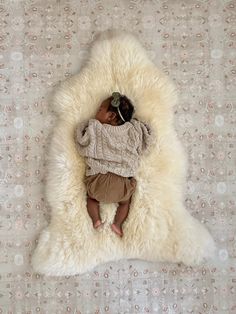 a baby is laying down on a white rug