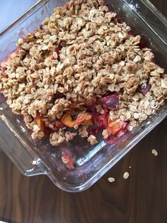 a glass dish filled with fruit and oatmeal crumbled in it