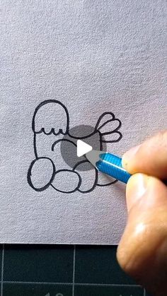 someone is drawing an apple logo on a piece of paper with a blue marker in their left hand