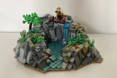 a lego man sitting on top of a mountain