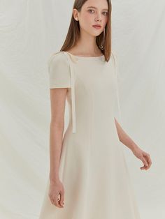 This product showcases a graceful midi dress with a flowing A-line skirt, designed to create an elegant and feminine silhouette. The dress features distinctive tie details at the shoulders, adding a charming touch to the simple yet sophisticated shape. With its fitted bodice and gently flared skirt, this piece offers both comfort and timeless style, making it suitable for various formal events. The shoulder ties serve as both a decorative and adjustable feature, allowing for a customized fit at the shoulders.The fitted bodice transitions smoothly into a flared skirt, accentuating the waist and providing a flattering drape.Its midi length is versatile and modest, suitable for a multitude of social settings and occasions.The dress is constructed with a discreet back zipper, making it ea Spring A-line Midi Dress With Bow, Spring A-line Midi Dress With Tie Straps, Chic A-line Maxi Dress With Tie Back, Fitted Knee-length Midi Dress With Tie Back, Elegant Midi-length Maxi Dress With Tie Back, Chic Midi Dress With Square Neck And Tie Back, Spring Workwear Midi Dress With Tie Back, Chic Square Neck Dress With Tie Back, Formal A-line Maxi Dress With Feminine Style