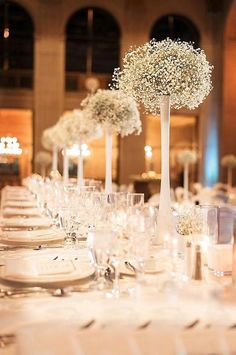 the table is set up with white flowers and candles for an elegant dinnereonal