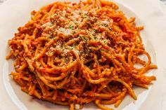 a white plate topped with pasta covered in sauce