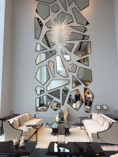 a living room filled with lots of mirrors on the wall and furniture in front of it