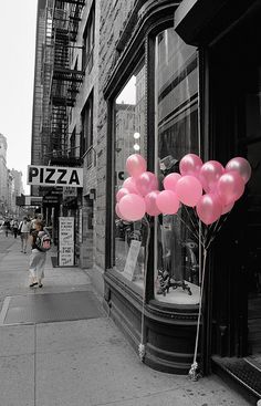 a bunch of pink balloons sitting in front of a store