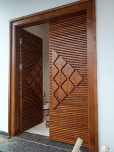 an open wooden door on the outside of a house with wood slats covering it