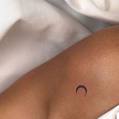 a woman's stomach with a crescent tattoo on it