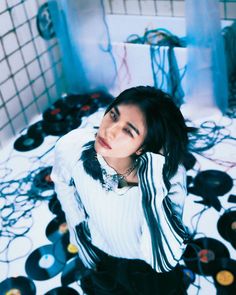 a woman sitting on the floor in front of record records