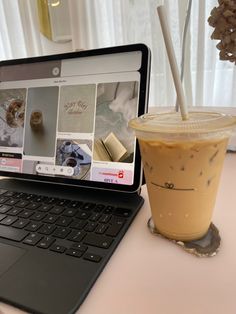 an open laptop computer sitting on top of a desk next to a cup of coffee