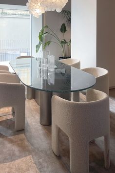 a glass table surrounded by white chairs in a room