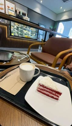 a piece of cake sitting on top of a plate next to a cup of coffee