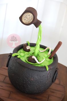 there is a cake in the shape of a caulder with green liquid coming out of it