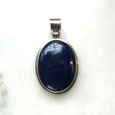 This is a vintage Denna Platero signed Navajo sterling silver necklace pendant set with a huge, polished lapis lazuli stone.  The stone measures 36mm long x 25mm wide.  There is visible pyrite in the dark blue lapis.  The bale is 9mm wide.  Total weight is 17.2 grams. This is a vintage, previously owned pendant.  Therefore, light wear can be expected.  There is no visible damage. Vintage Lapis Lazuli Gemstone Jewelry, Elegant Lapis Lazuli Oval Cabochon Jewelry, Elegant Oval Cabochon Lapis Lazuli Jewelry, Silver Lapis Lazuli Jewelry For Formal Events, Silver Lapis Lazuli Jewelry For Formal Occasions, Formal Silver Lapis Lazuli Jewelry, Vintage Lapis Lazuli Oval Jewelry, Vintage Oval Lapis Lazuli Jewelry, Vintage Lapis Lazuli Jewelry As Gift