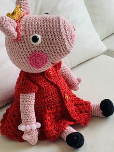 a crocheted pig sitting on top of a white couch