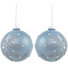 two blue christmas balls hanging from chains on a white background with snowflakes in the middle