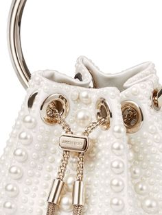 Find JIMMY CHOO Bon Bon Pearl-embellished Mini Bag on Editorialist. This Jimmy Choo Bon Bon mini bag is crafted from ivory satin with a pearl embellishment throughout. It features a logo engraved silver-tone hardware, metal tassel detail, chain-link shoulder strap, single metallic top handle, drawstring fastening, main compartment, and internal logo patch. Jimmy Choo Gold, Statement Handbag, Metal Bracelet, Bon Bon, Satin Top, Metal Bracelets, White Bag, Fun Bags, Lalique