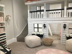 a doll house with white walls and stairs in the middle of a living room filled with furniture