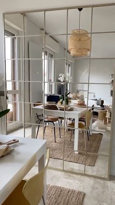 the reflection of a dining room table and chairs in a large mirror on the wall