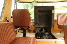 the inside of a vehicle with leather seats and a wood burning stove in the center