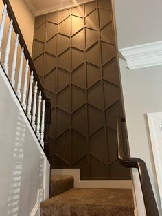 stairs leading up to the second floor with decorative wall paneling on the walls behind them