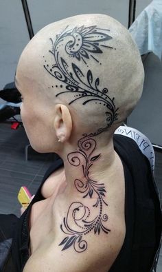 a bald man with a tattoo on his neck and head is seen from the back