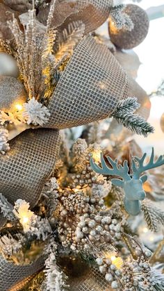 a christmas tree is decorated with burlocks and silver ornaments, including an antler ornament