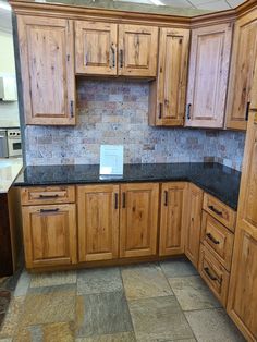 a kitchen with wooden cabinets and black granite counter tops in the middle of the room