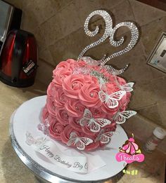 a birthday cake with pink roses and butterflies on it's tiered base, decorated with the number twenty two