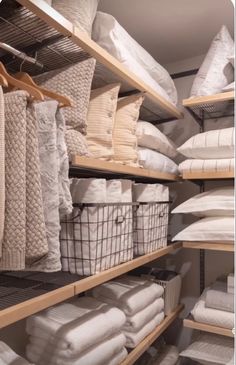 the shelves are filled with white linens and pillows