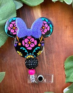 a mickey mouse head with flowers on it and a camera attached to the front of it