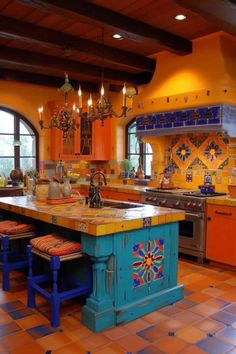 an orange and blue kitchen with lots of counter space in the center, along with colorful tiles on the floor