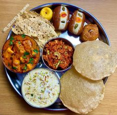 a plate filled with different types of food on top of a wooden table next to bread