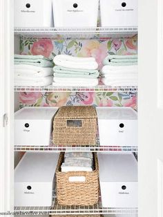 an organized closet with baskets and linens on the bottom shelf, white bins in between