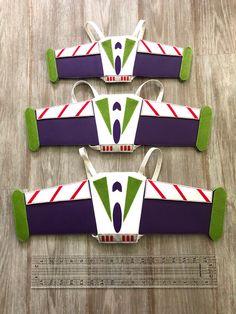 three toy cars are sitting on top of a wooden floor with green and purple trims