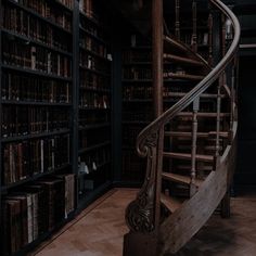 a spiral staircase in an old library with bookshelves and shelves full of books