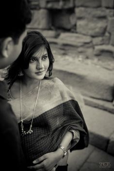 a black and white photo of a woman in a ponchy with her hand on her hip