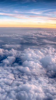 the view from an airplane window shows clouds and blue sky