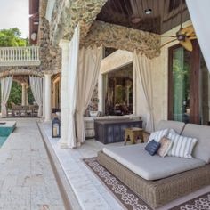 an outdoor living area with couches, table and pool