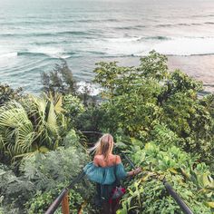 a woman walking up some stairs near the ocean