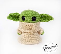 a crocheted baby yoda doll with black eyes