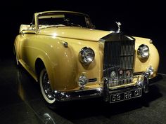 an old yellow car is on display at the museum