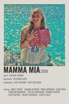 the poster for mamma mia is shown in front of water with rocks and blue sky