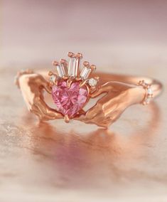 Exquisite and delicate Claddagh ring with pink sapphire heart and baguette diamonds crown. Traditional irish promise ring, beautiful symbol of love (heart), friendship (hands) and loyalty (crown). Modernized design of this ring makes it perfect heirloom piece of our days, that will become your real heritage. About this item: -Pink sapphire (~0,5ct) and diamonds G-H color.Total carat weight ~ 0.55 -Heart stone can be customized, please feel free to write me for variations. -Solid 10K Rose, Yellow Wedding Ring Heart, Claddagh Wedding Ring, Irish Ring, Claddagh Ring Wedding, Heart Wedding Rings, Fantasy Earrings, Heart Promise Rings, Irish Rings, Alternative Engagement Ring