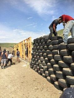 people are standing on top of a pile of tires