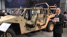 a man standing next to an armored vehicle