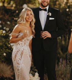 a man in a tuxedo standing next to a woman wearing a wedding dress