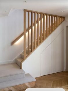 an empty room with wooden stairs and white walls