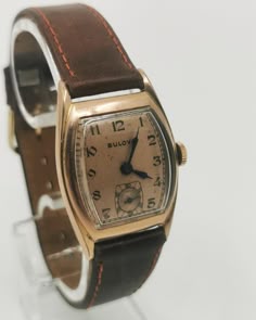 Rare 1940s original BULOVA CURVEX TANK with brand new brown saddle leather strap and with a very well preserved Curvex glass, with sought-after, salmon-colored original dial with black, Arabic indexes and original, blued steel pointers. Original legendary BULOVA caliber 10BC with 15 jewels, watch runs perfectly for it's age. Worth collecting, original timeless classic in good condition! Vintage Brown Formal Watches, Antique Brown Analog Watch, Vintage Brown Leather Watches, Vintage Formal Watch With Leather Strap, Vintage Brown Watch With Leather Strap, Vintage Brown Watches With Leather Strap, Brown Retro Formal Watch, Vintage Brown Leather Watch, Vintage Watches With Leather Strap