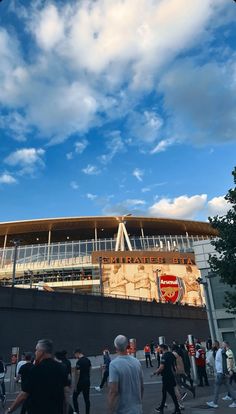 people are walking around in front of a stadium