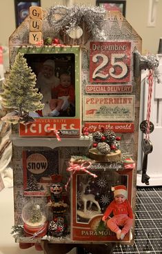 a christmas display with an old fashioned doll house and decorations on it's side